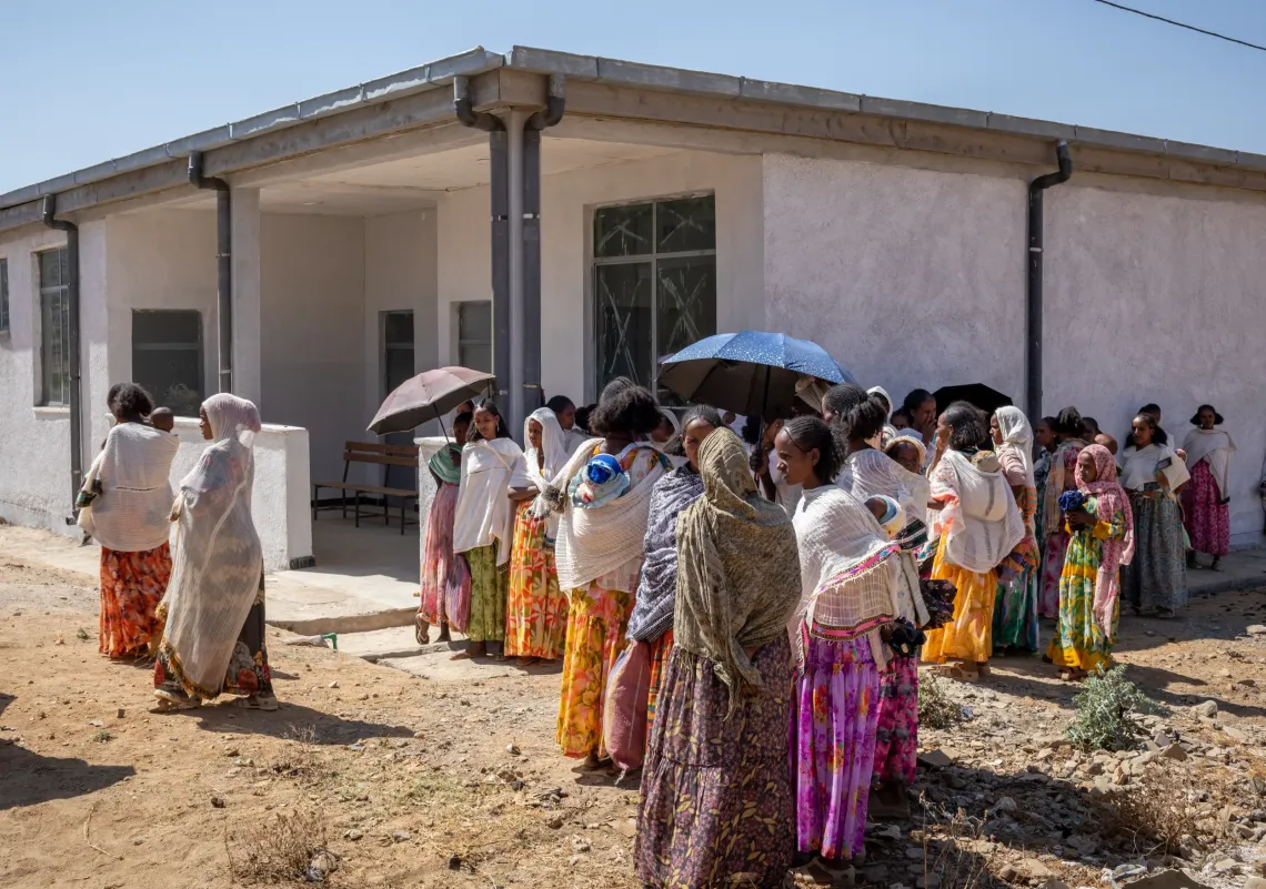 Mothers patiently waiting and standing in line to get their children vaccinated