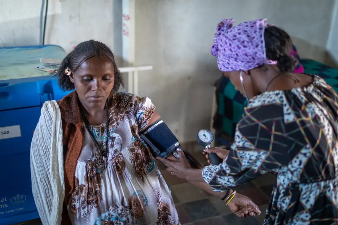 A pregnant mother getting checked by a health worker