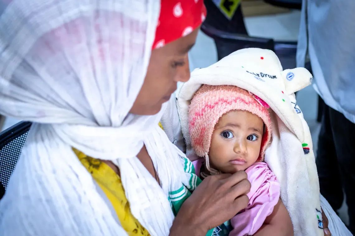 A mother holding her baby in her hand 