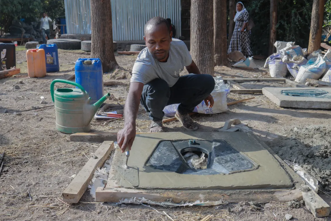 A man producing precast latrine slabs