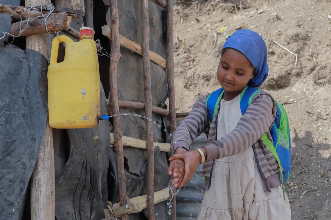 A little girls washing her hand