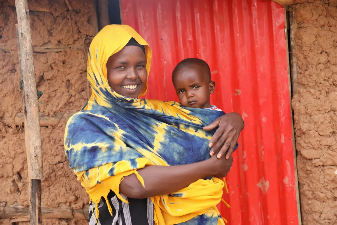 Hamdi Abduwaha holding her baby and posing for a photo