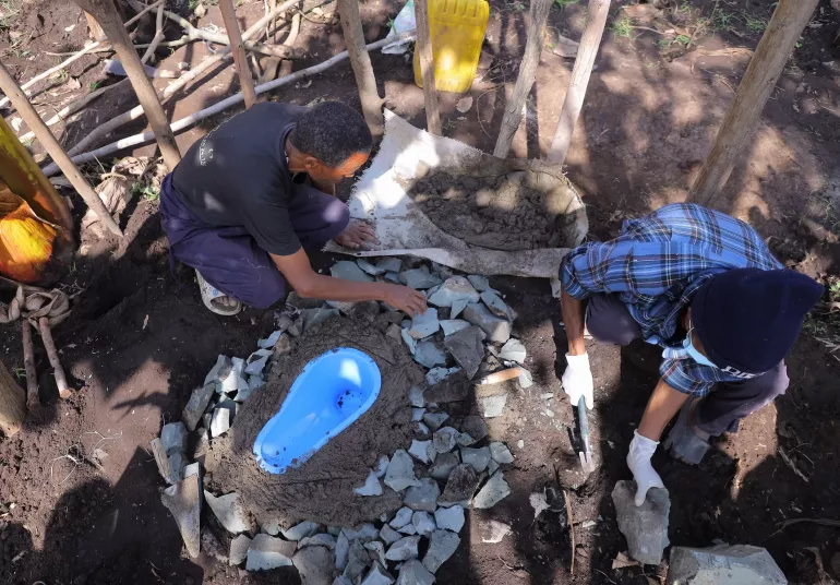 A young man upgrading unimproved latrine 