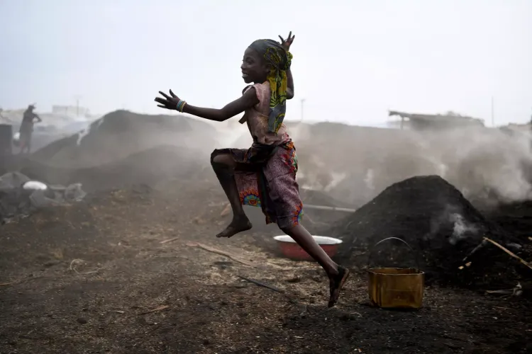 children working in a charcoal production field in the town of San Pedro, in the South West of C&ocirc;te d'Ivoire, in an atmosphere filled with heat, dust and smoke.  In C&ocirc;te d'Ivoire, 1 in 5 children children work often in very difficult conditions such as this one.