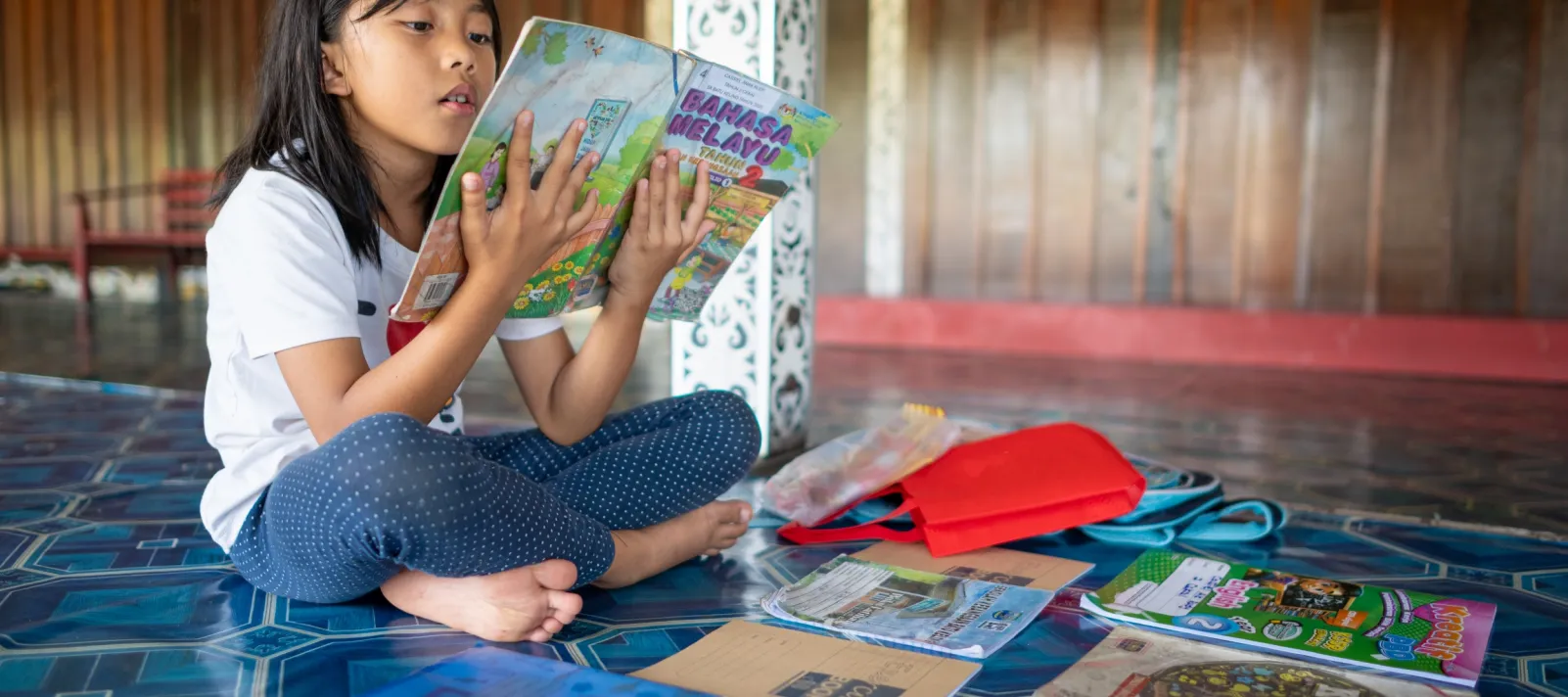 8 year-old Carlissa unpacks her books and school supplies for the day at school