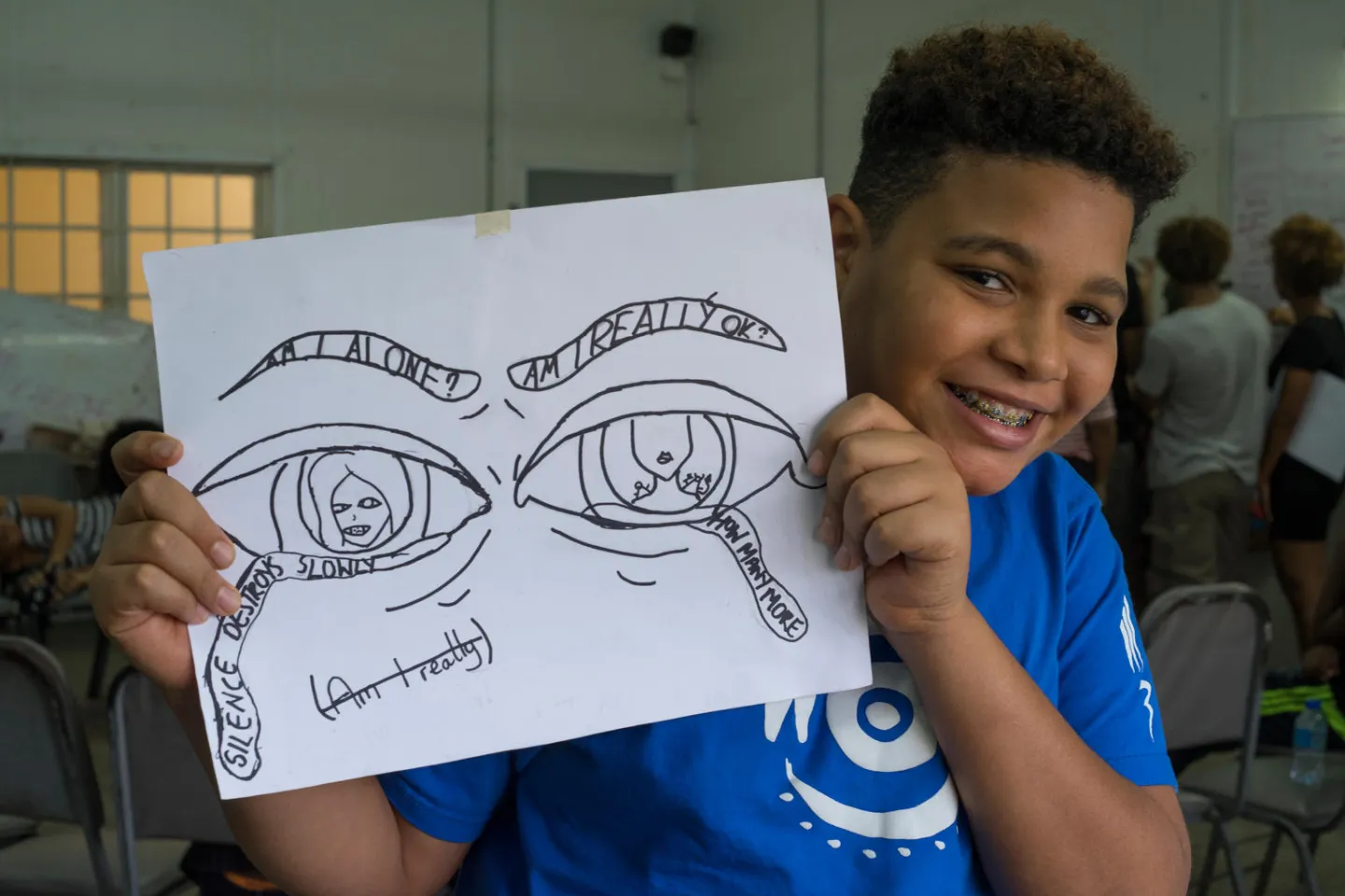 Elliot Ross-Dick, 13, holds up his group's concept for a mural, Trinidad & Tobago.
