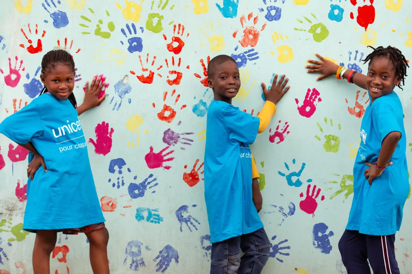 This documentary image depicts the realities of the current situation. Physical distancing and the use of personal protective equipment (PPE), including masks, portrayed in this image may not necessarily align with current WHO guidance on COVID-19. Yasmine, Farouk and Mariam, are enjoying a photo shoot for World Children's Day in Abidjan, in south of C&ocirc;te d'Ivoire.