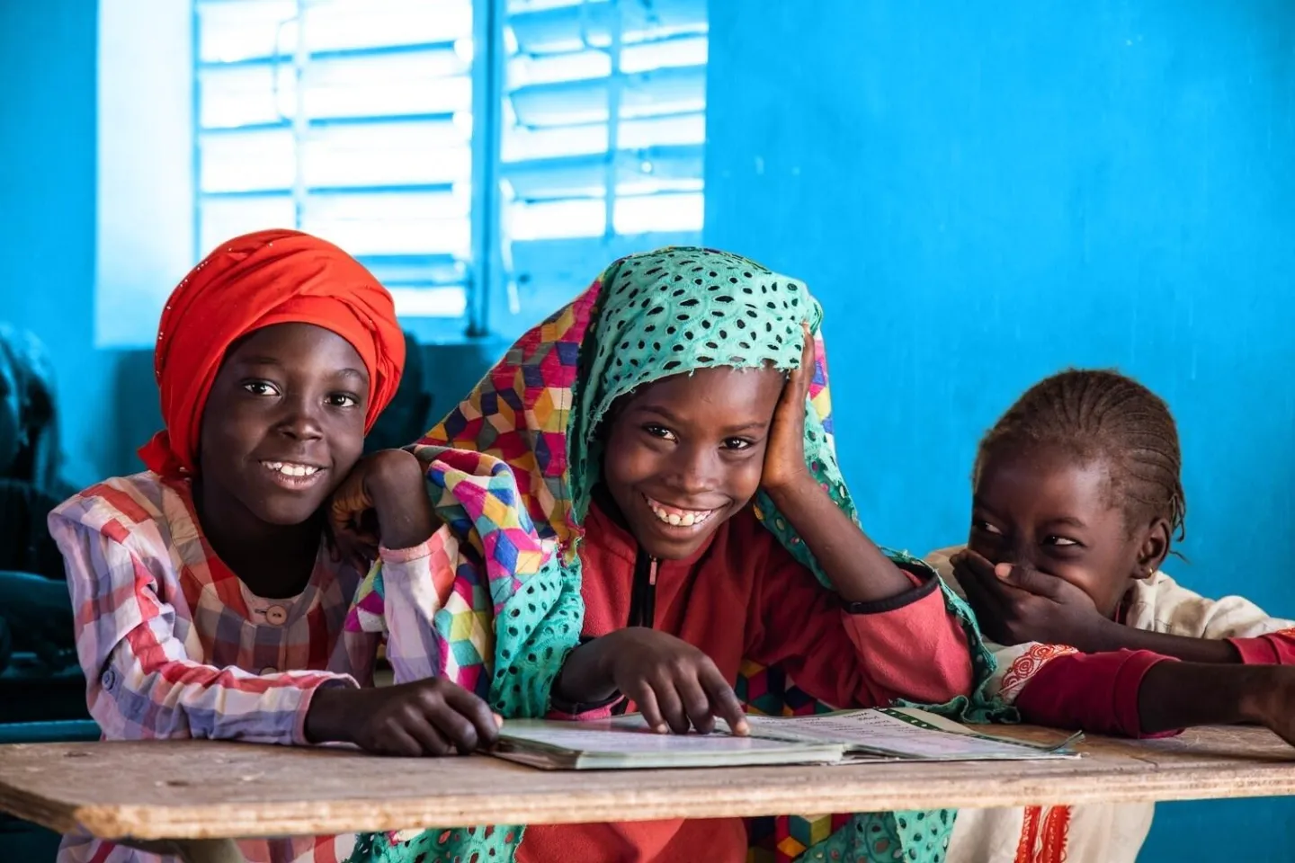 In Senegal, a group of girls laugh as they attend classes at the Franco-Arab school Diamaguene center.