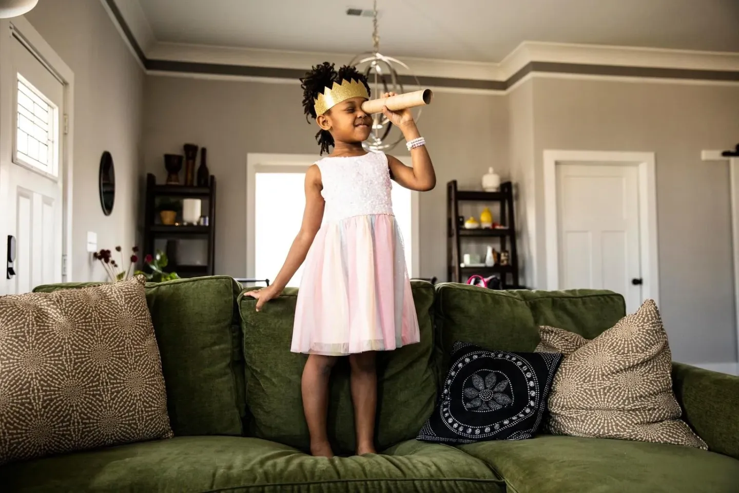 Royalty-free stock photography asset purchased in August 2023, does not show a UNICEF intervention or programme participants. &nbsp;Young girl wearing homemade crown and looking through homemade telescope