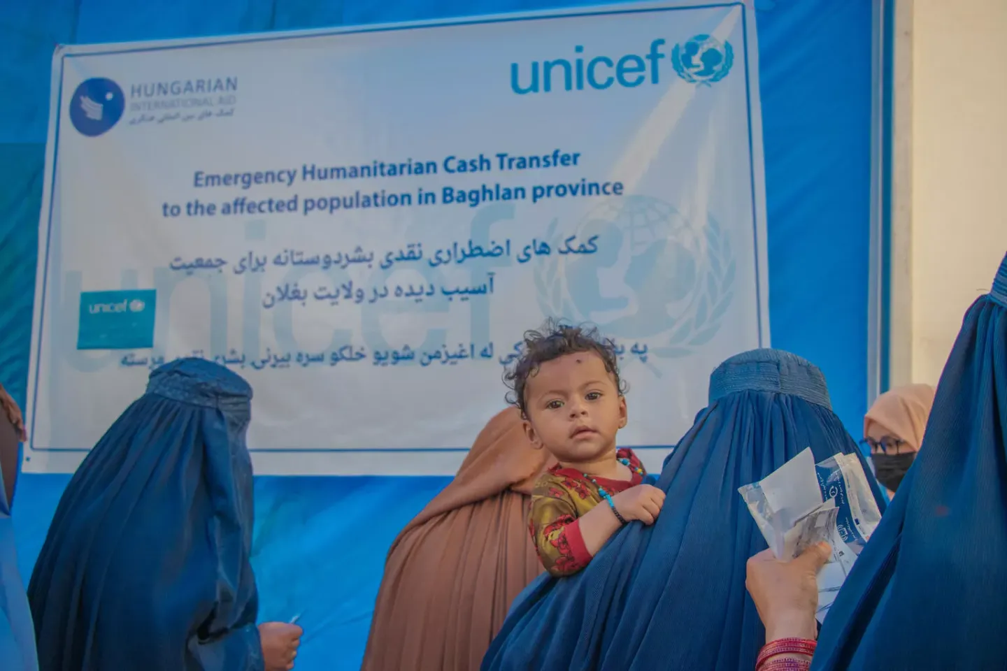 Women stand in line to receive cash assistance from UNICEF after the flash floods destroyed their homes in Darwazaha village, Baghlan province, Afghanistan.