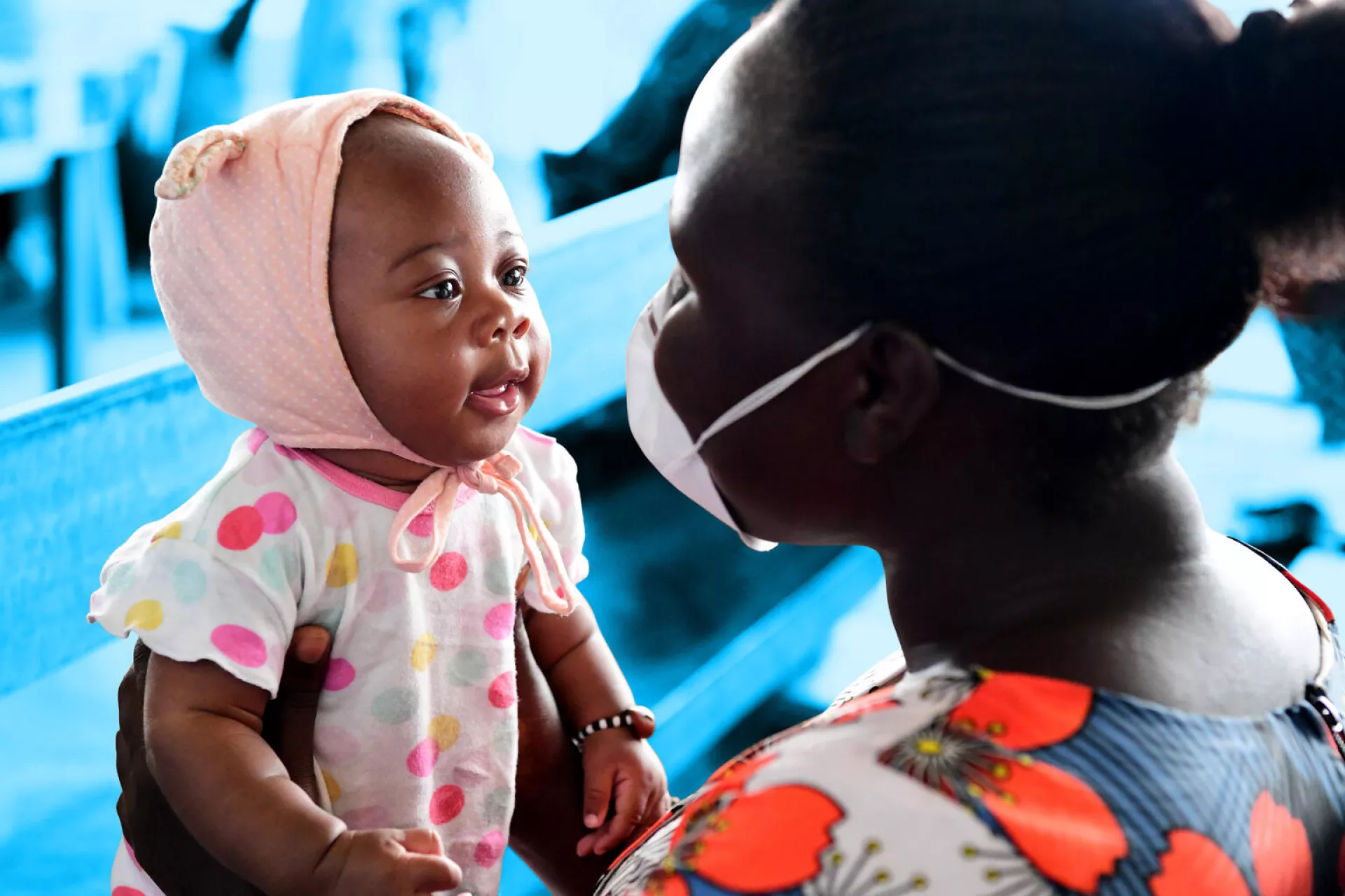 Christelle, a 3 months old baby is waiting to be weighted and vaccinated in the health center of Gonzagueville, a suburb of Abidjan, in the South of C&ocirc;te d'Ivoire. Anna, the 29 years old mother of 4 children, is wearing as mask to protect herself against the Coronavirus.