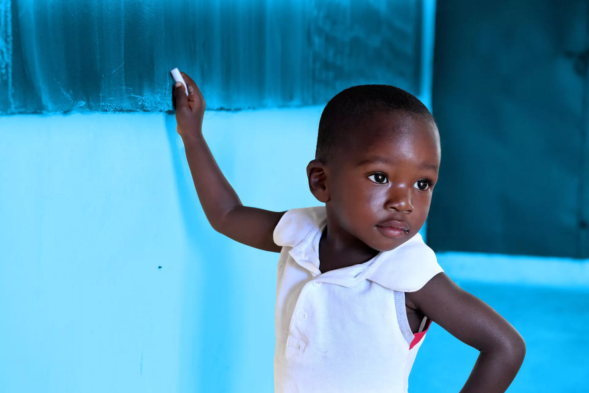 A young boy at the billboard at a school, in Touba, in the West of C&ocirc;te d'ivoire. For every child, education.