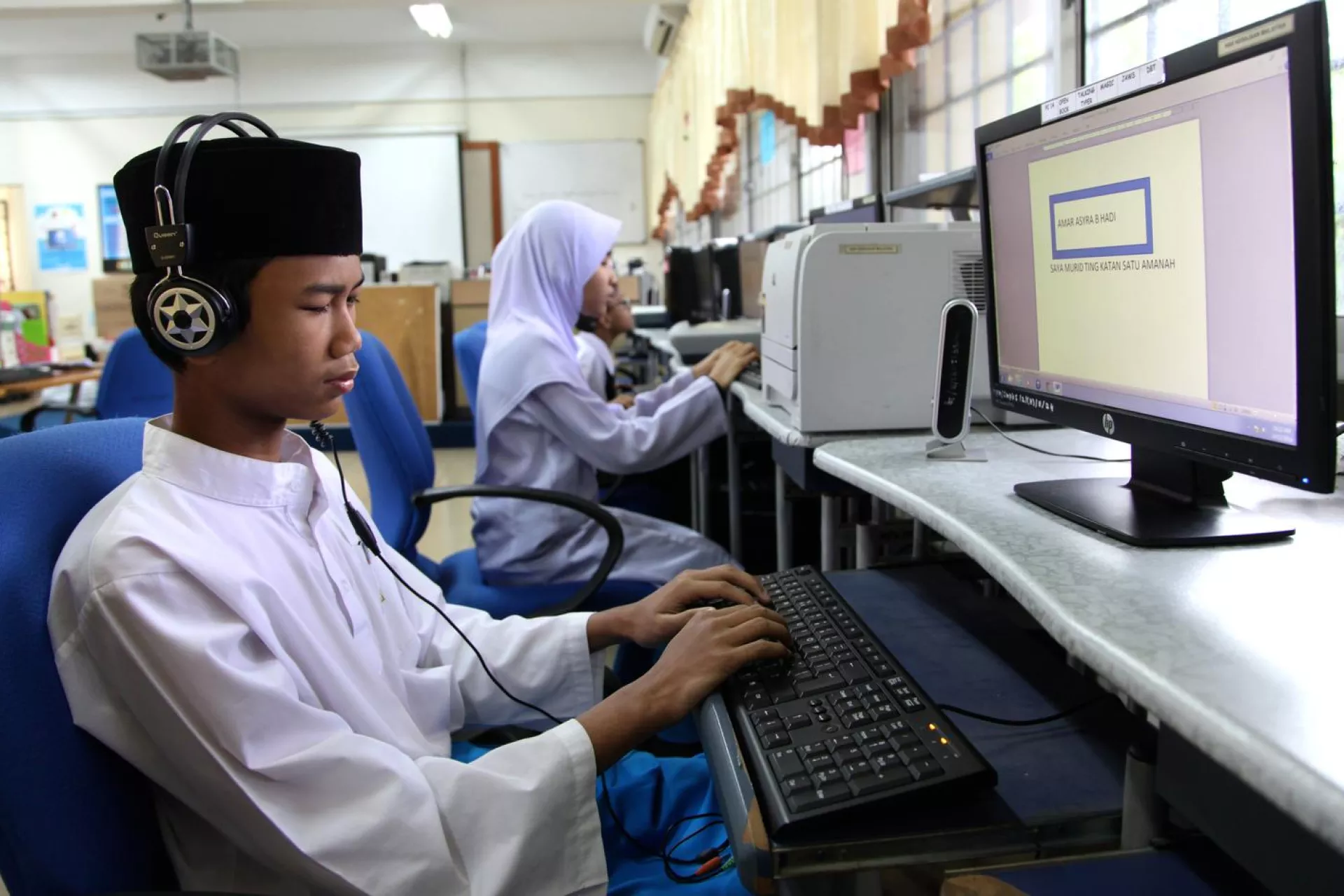 In Malaysia, an adolescent boy who is blind uses a computer with text-to-speech