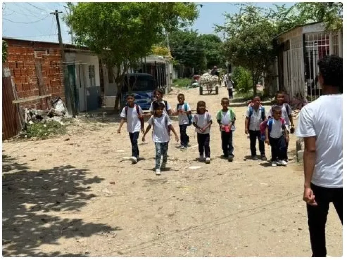 Children walking from school in Soledad El Povenir, Barranquilla, Colombia, where informal settlements have emerged due to the Venezuelan migration crisis. The community engages and cares for the kids, providing volunteer-based education and activities like recycling.
