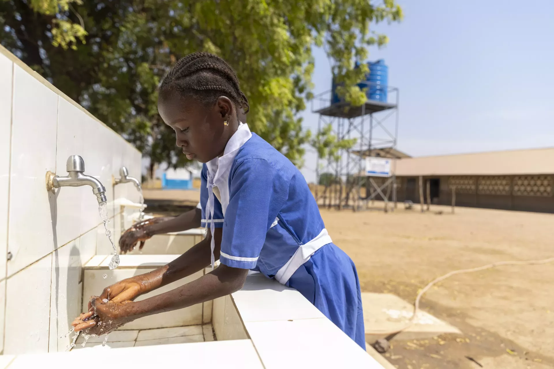 Pupils walk past a water tower, build by UNICEF, at a school in Njoben.