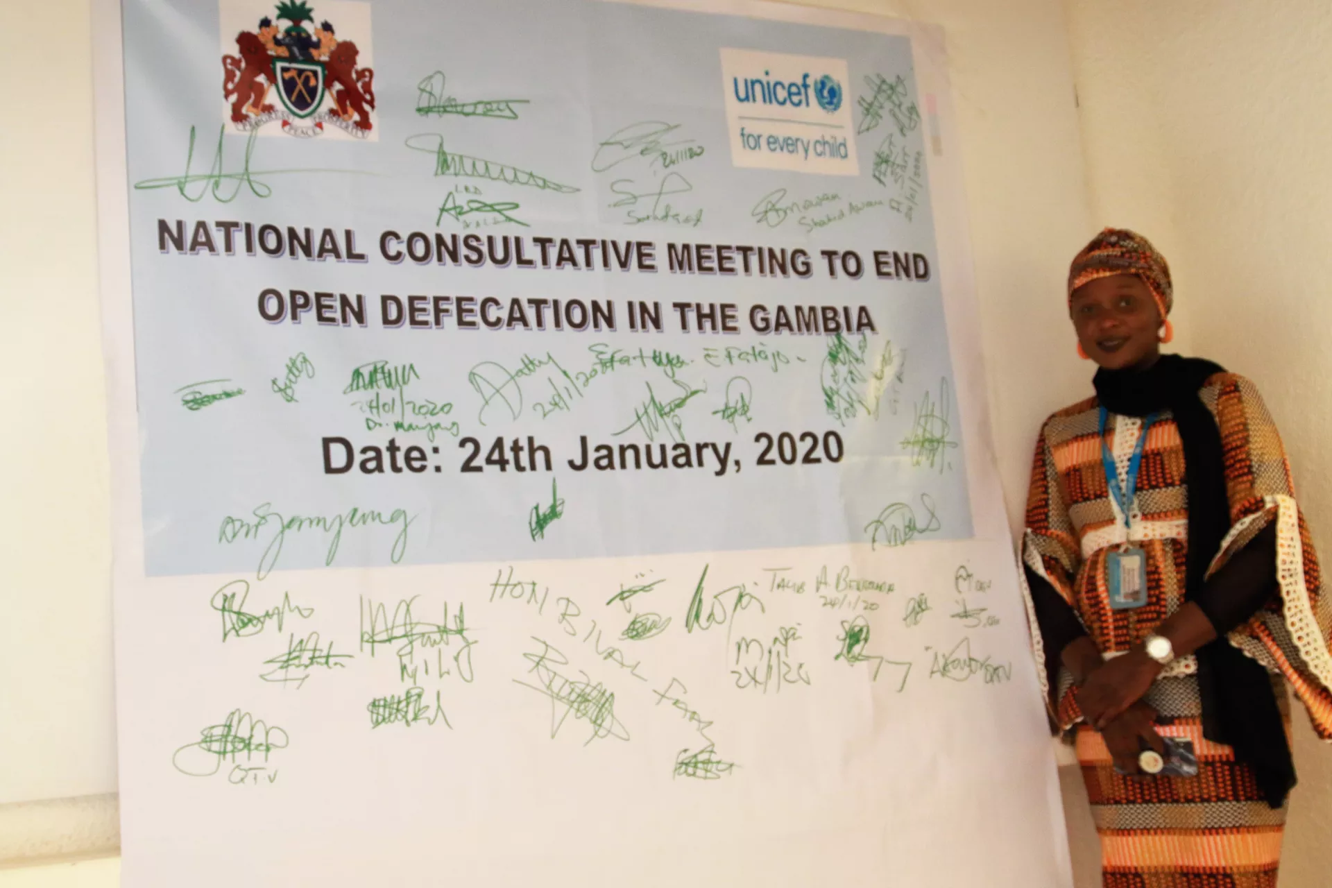 UNICEF staff stands beside a banner bearing the pledges of government and partners to end open defecation