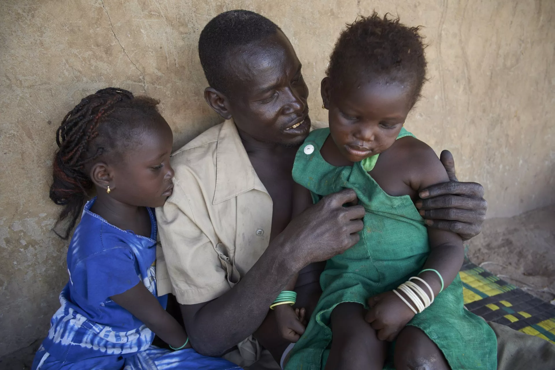 A father comforts his two daughters