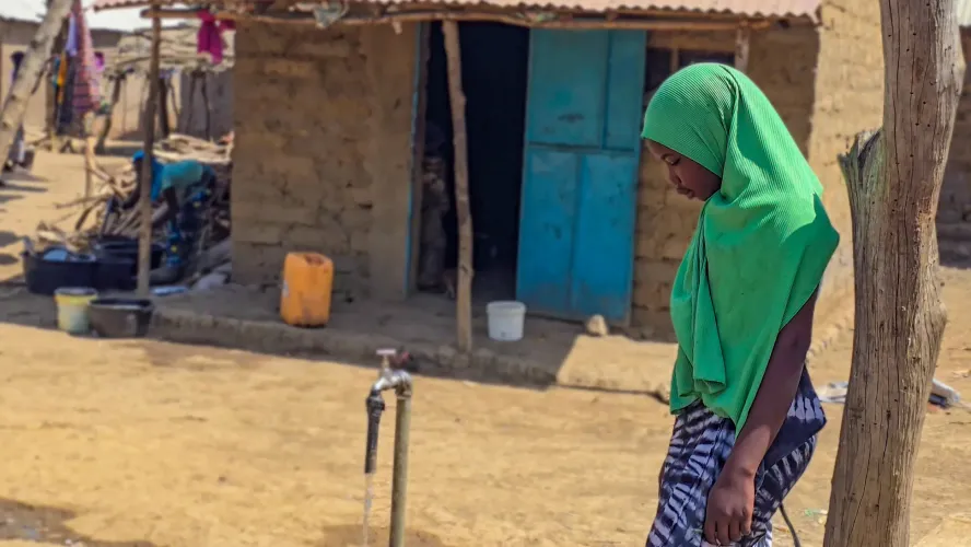 Fatoumatta, 16, fetches water from a tap in Sambel Dakka