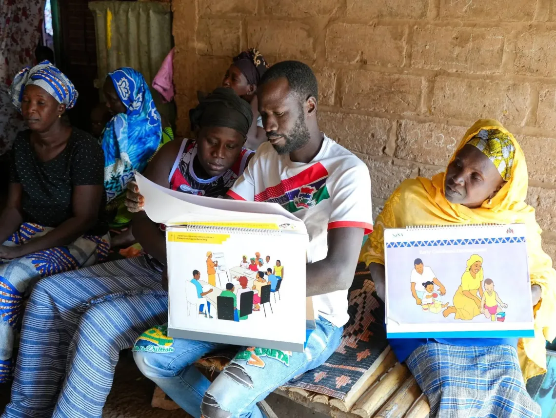 Babucarr Secka, one of the few male members of Group Nampal, engaging women in his community about the group's work.
