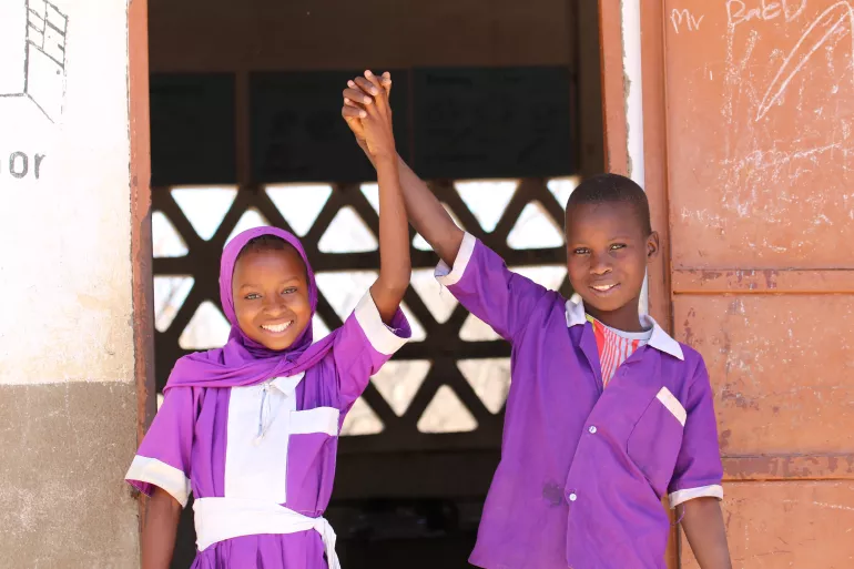 Two students hold hands together