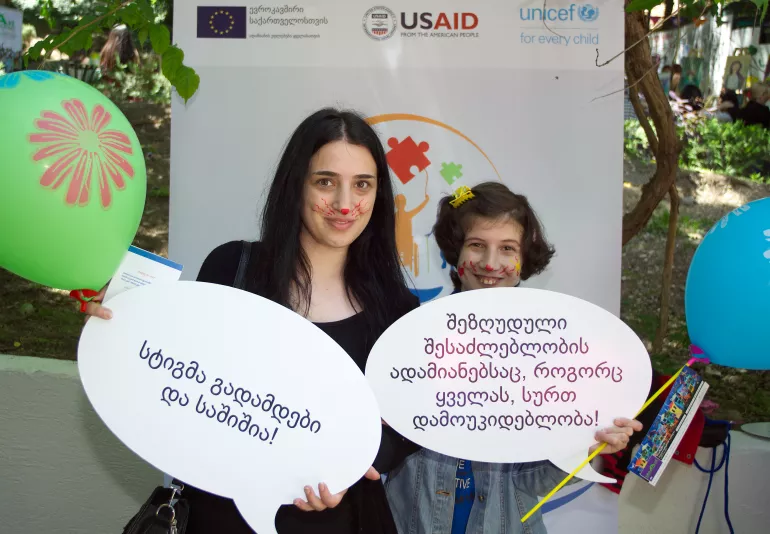 Children holding banners with anti-stigma messages