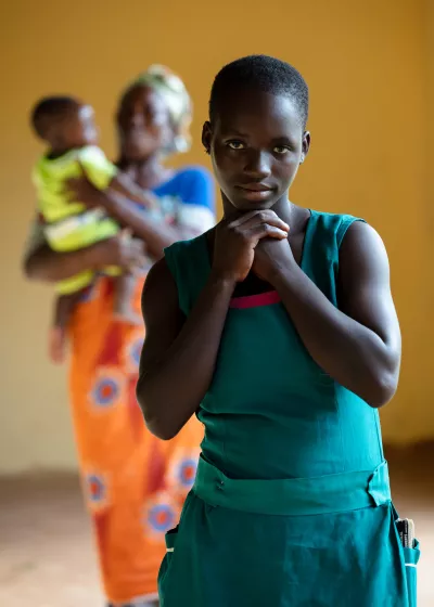 Peace, 16, in front of her mother and baby