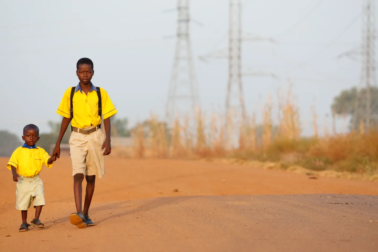 Boys in yellow uniforms hold hands as they walk to school in Tanzui, Ghana on Thursday November 11, 2010.