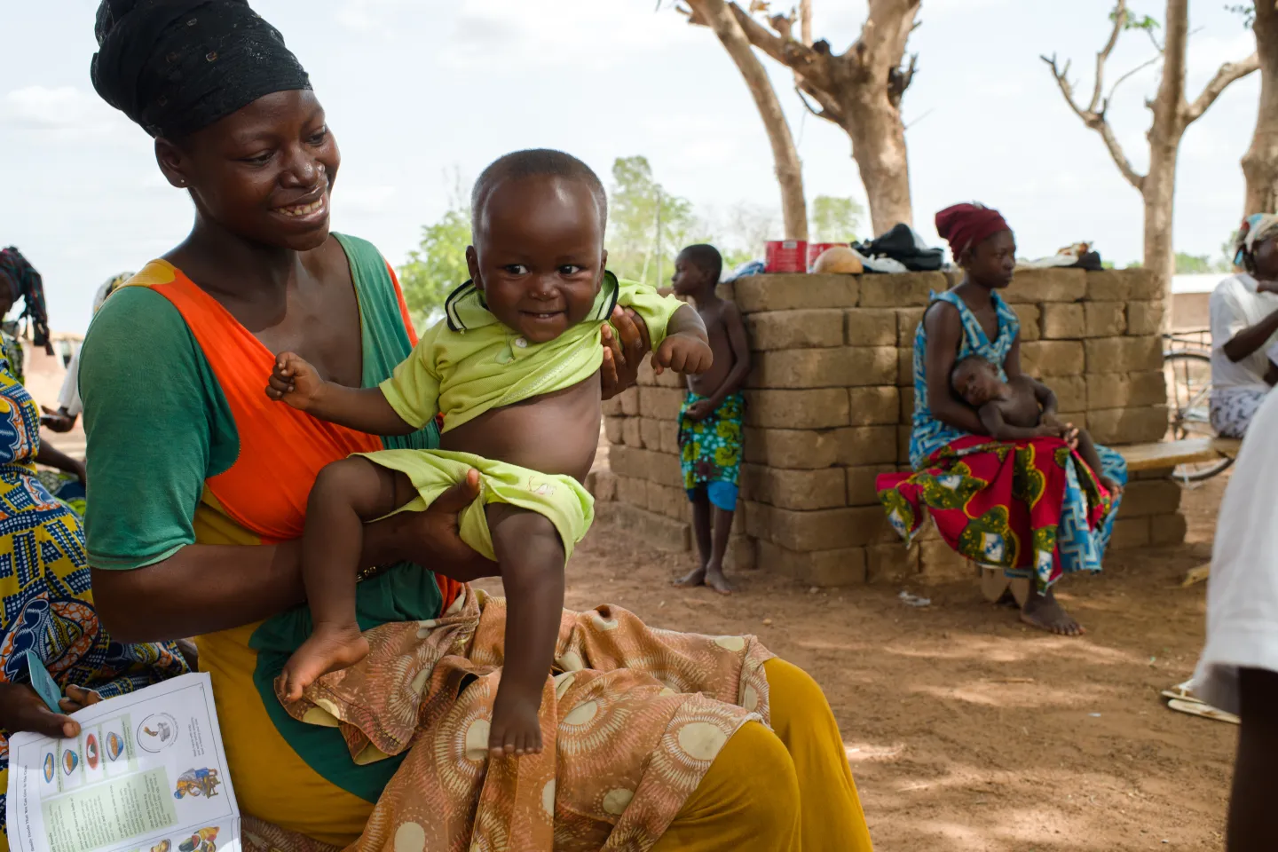 Woman with baby waiting to be registered for social protection support