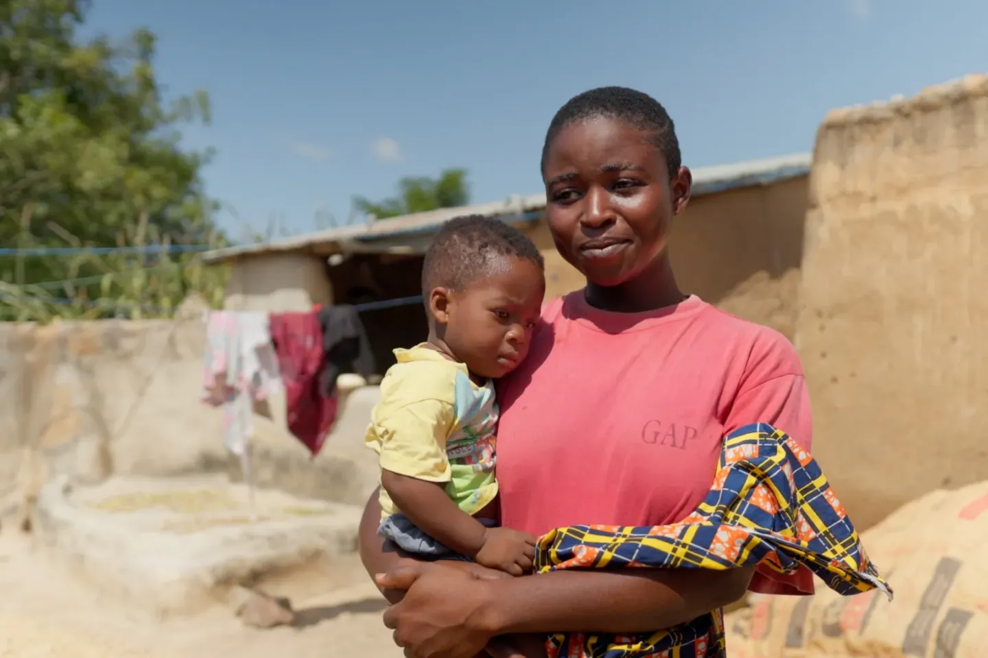 Beatrice and her one-year-old baby pose for a photograph in their home at Zorkor. 