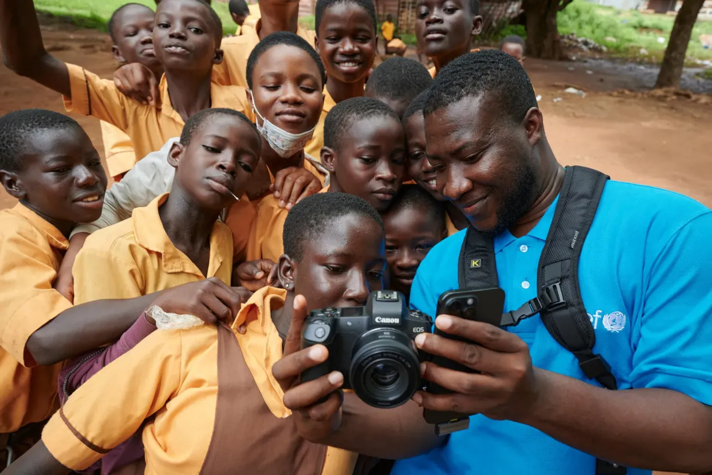 Stephen Ofori Amo shares photos with children at Choggu Yapalsi Junior High School, a Nutrition-Friendly School and a beneficiary of many UNICEF-supported interventions.