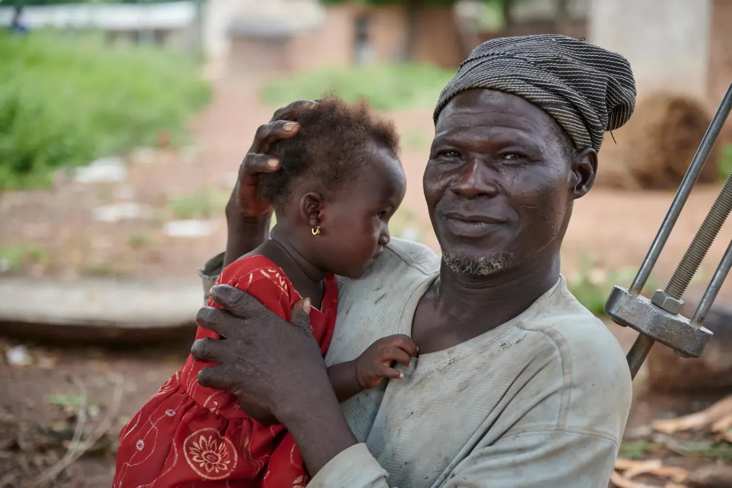 Sitting under a tree, Yoosuf looks after his daughter Radia in a remote community in North East Gonja sub district in Northern Ghana.
