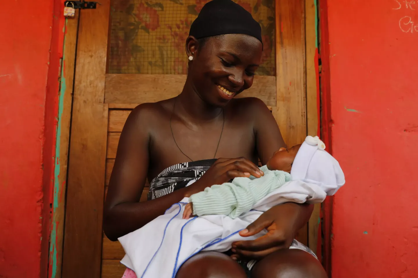 A mother holds her child in the arms.