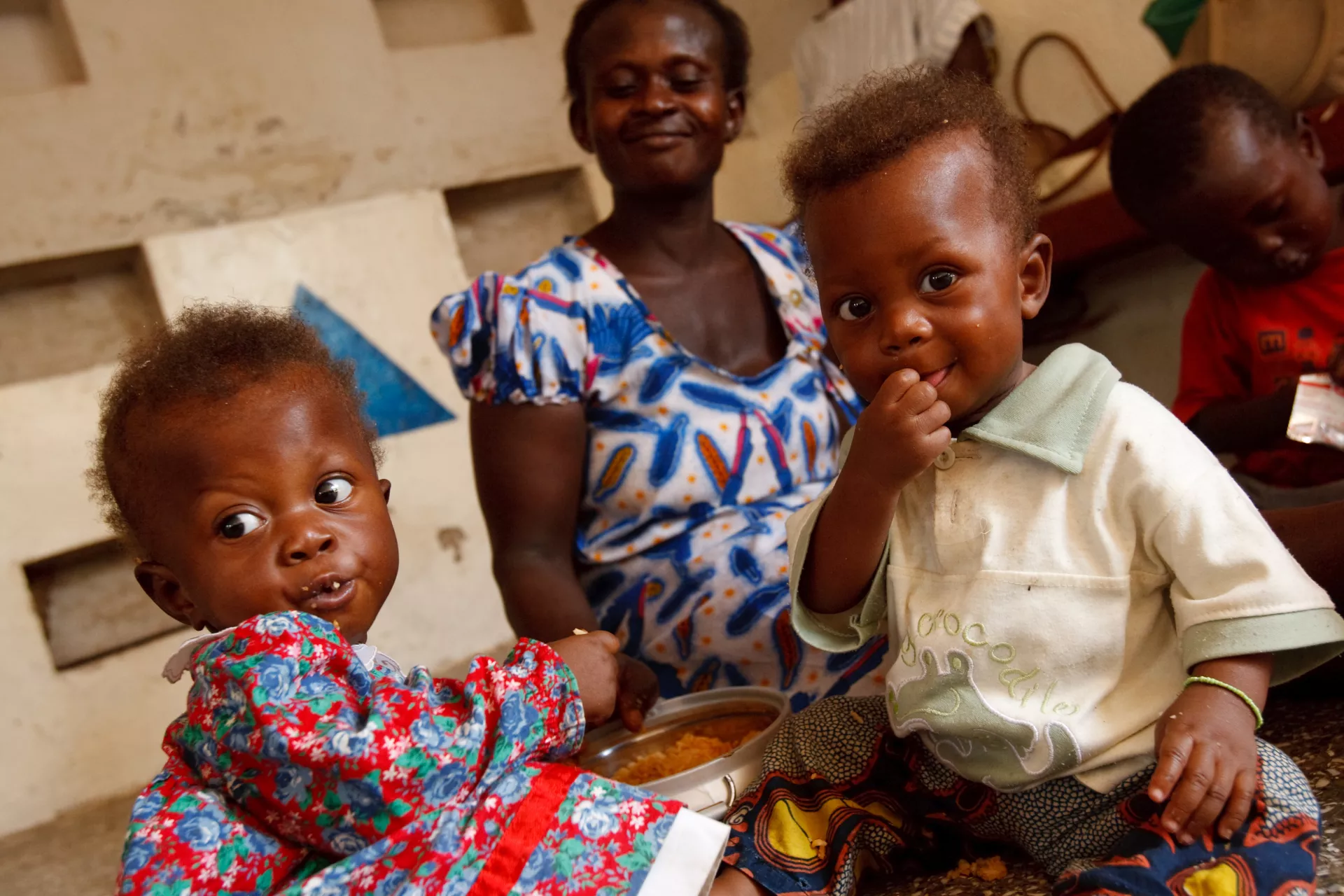 Elizabeth Akansaka feeds her twins Jessie and Jessica in Bolgatanga