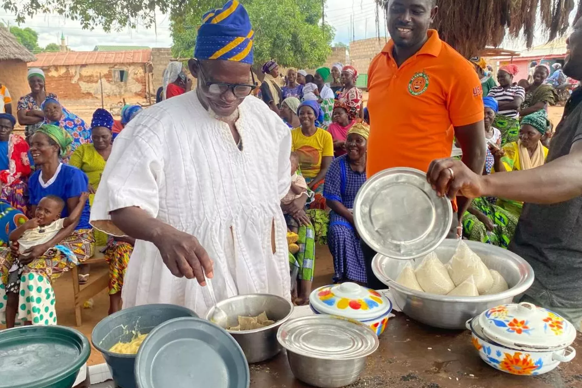 A traditional leader from the community inspects the food prepared 