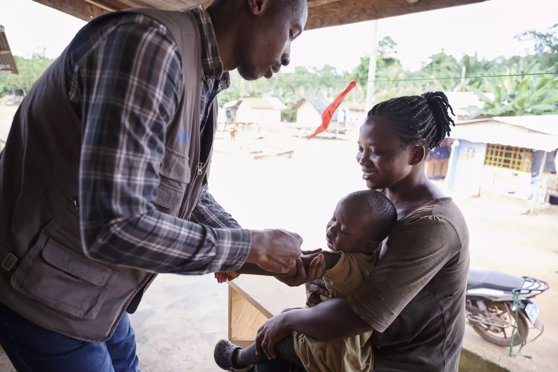 Diana watches as her son Justice gets vaccinated by the health worker.