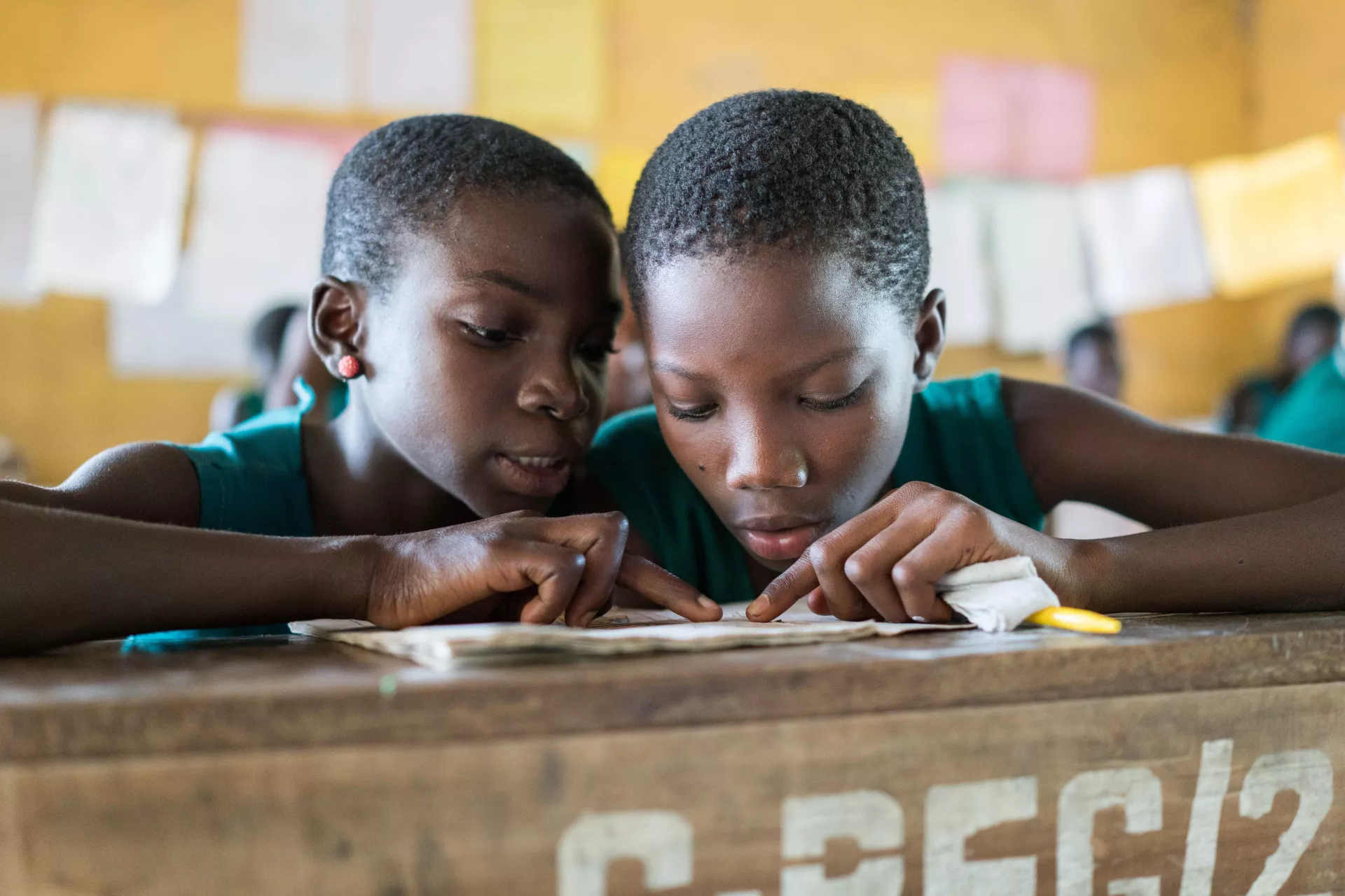 Two schoolchildren learning to read in classroom