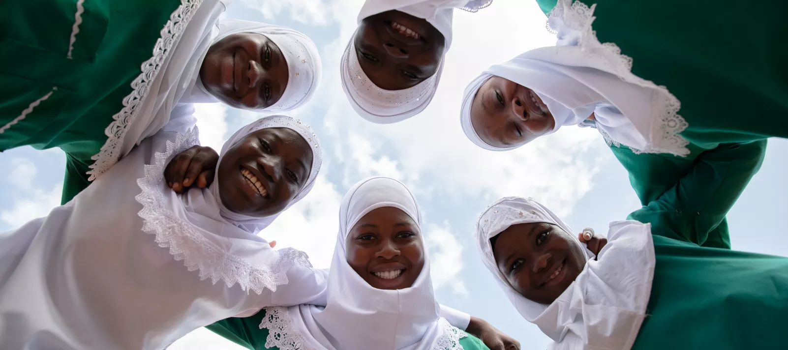 A group of girls huddle together for a photo