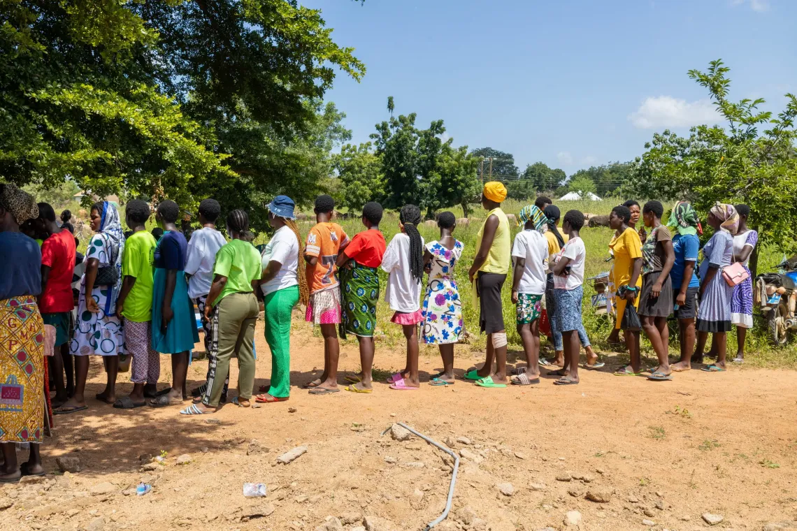 A chorus of girls, including Beatrice, waiting in line to ensure they are registered for the program.