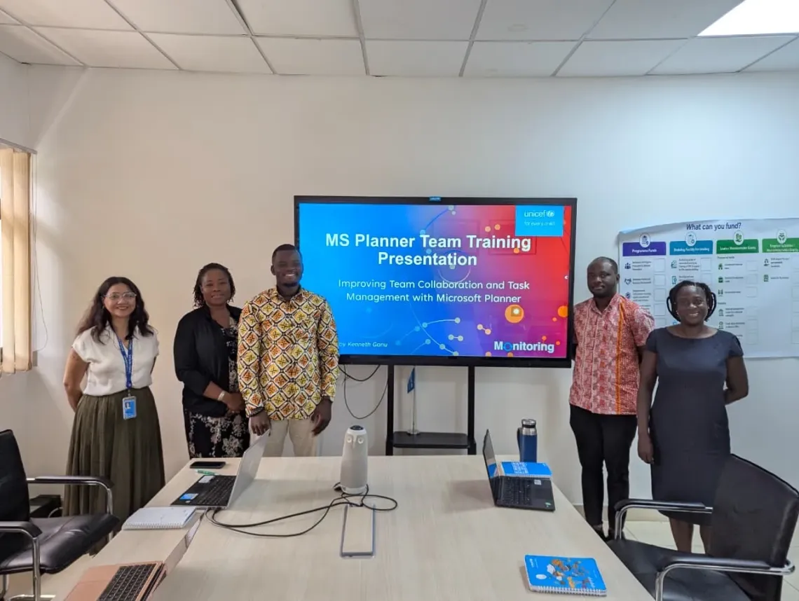 Kenneth poses with colleagues from his team during a work presentation