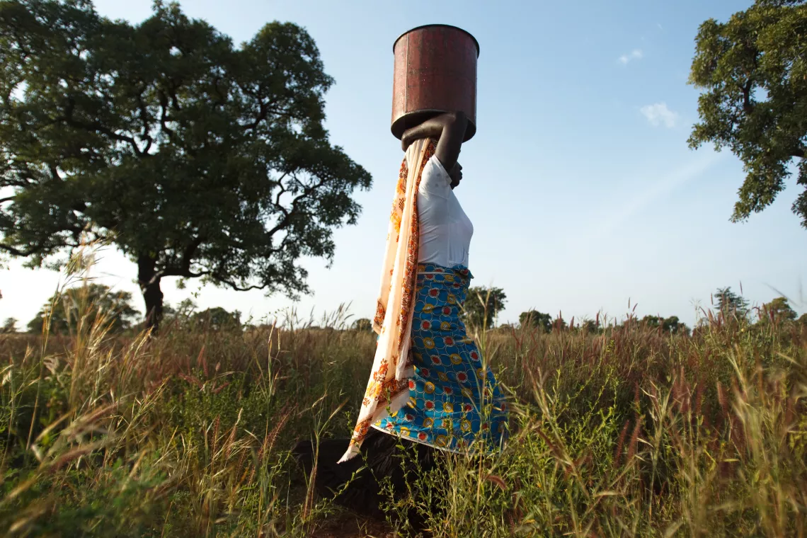 A woman carries a basin of water on her head 