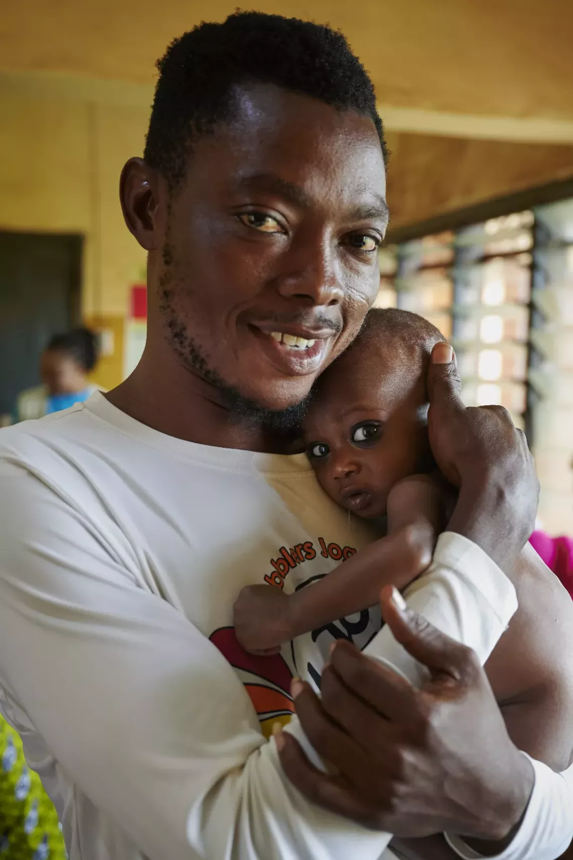 Yussif holds Hilder as he arrives at the weighing center