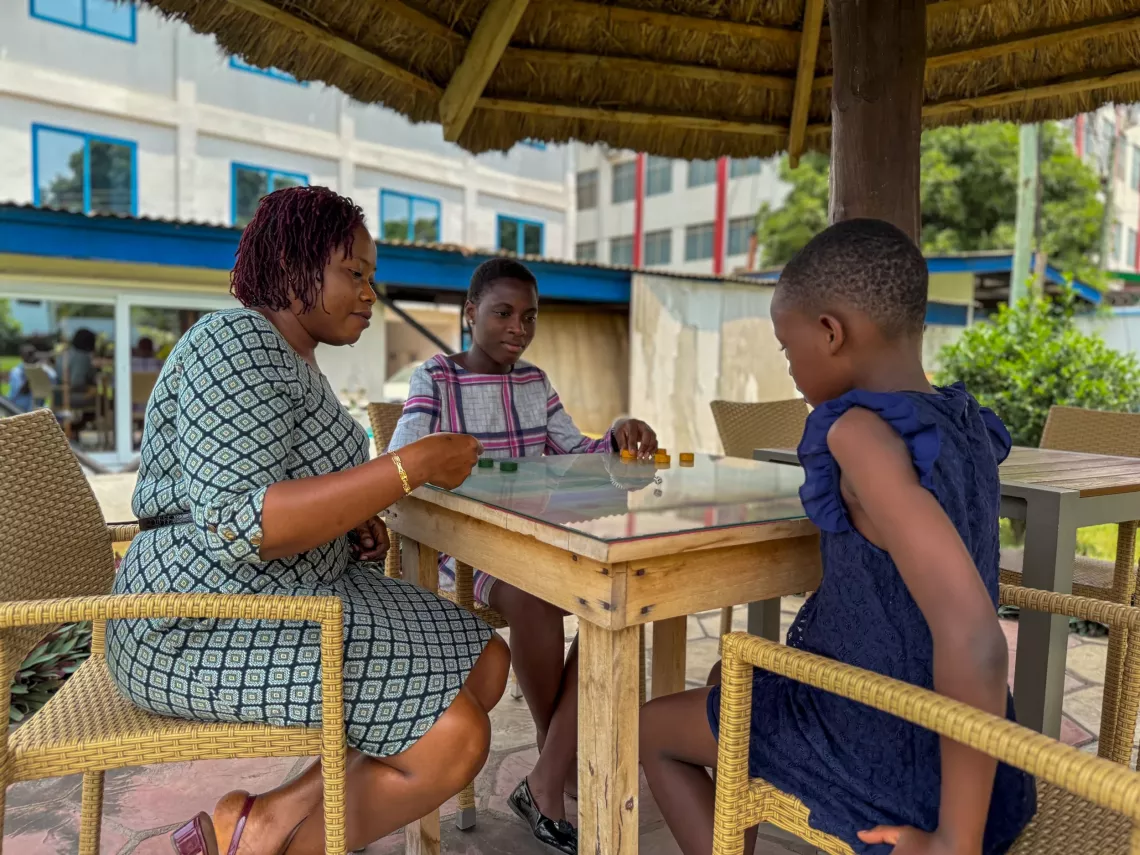Miriam plays a game with her children.