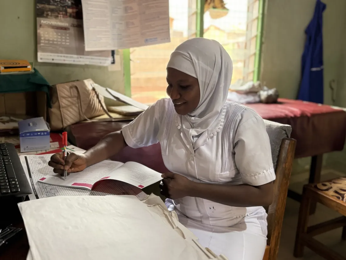 A health worker enters a patient's record.