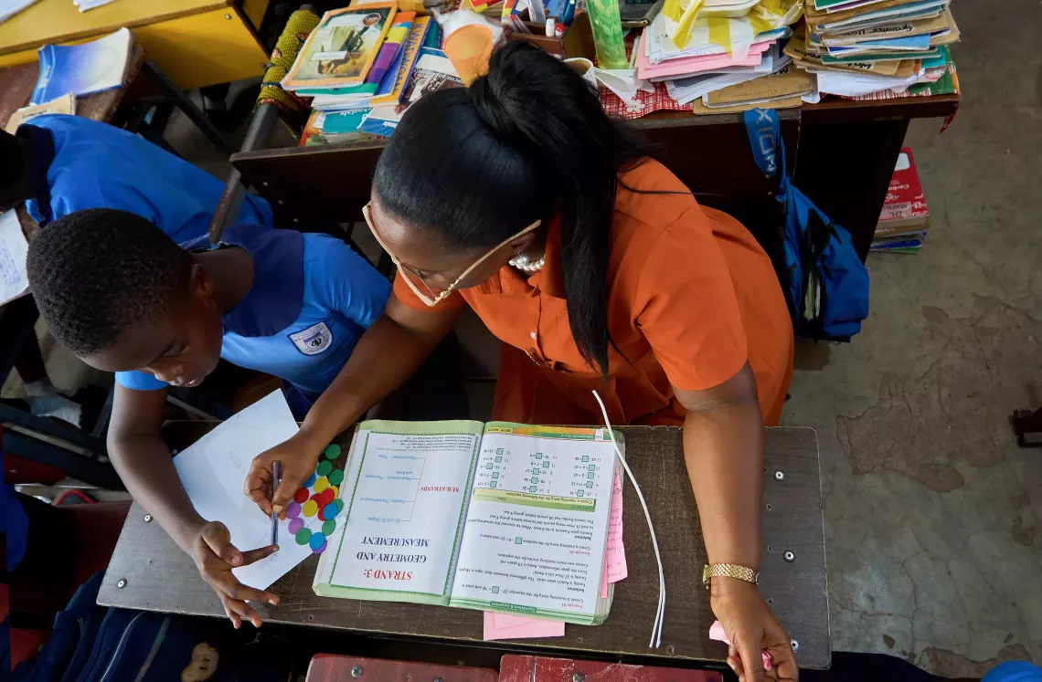 A girl shows her teacher the answer after solving a math problem.