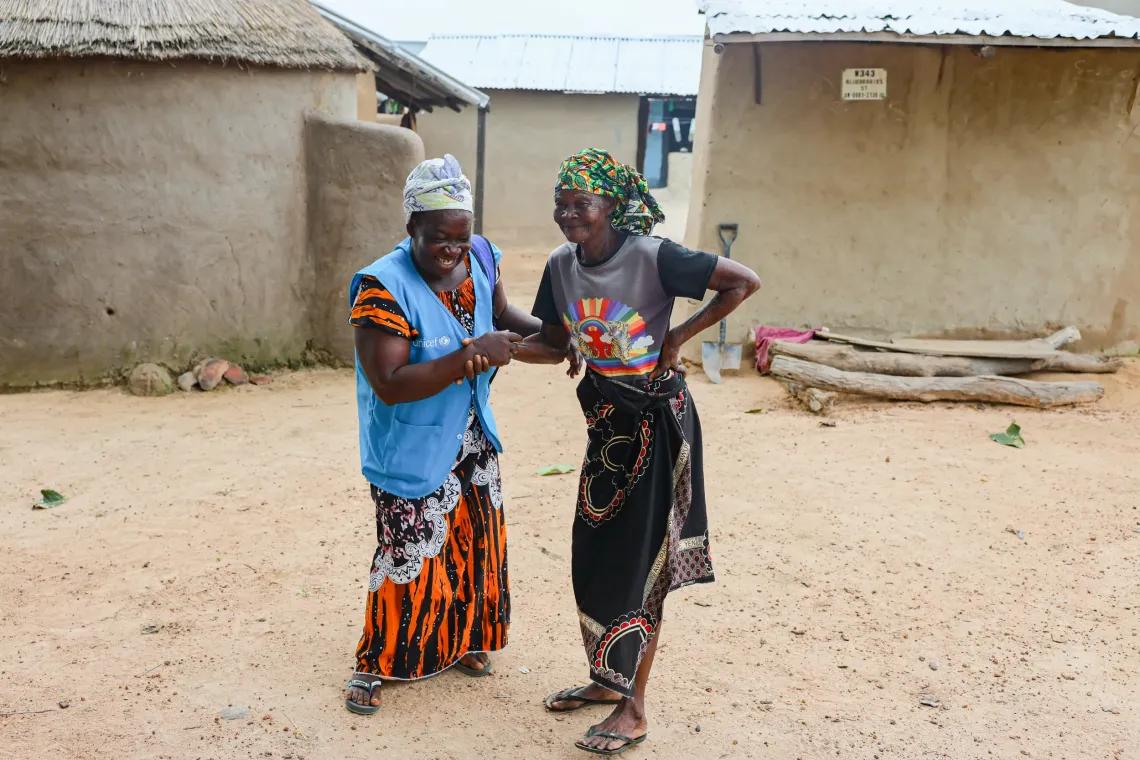 Community volunteer Adiyan Abena shares a light moment with a community member during a home visit in Tarikom, Ghana's Upper East Region.