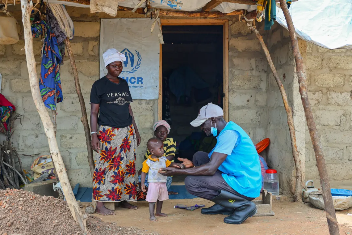 Community volunteer Moses Kwaku engages a refugee family during his home visits in Zini, the Upper West Region of Ghana.