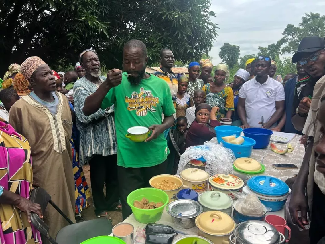 A community member tastes the food prepared. 