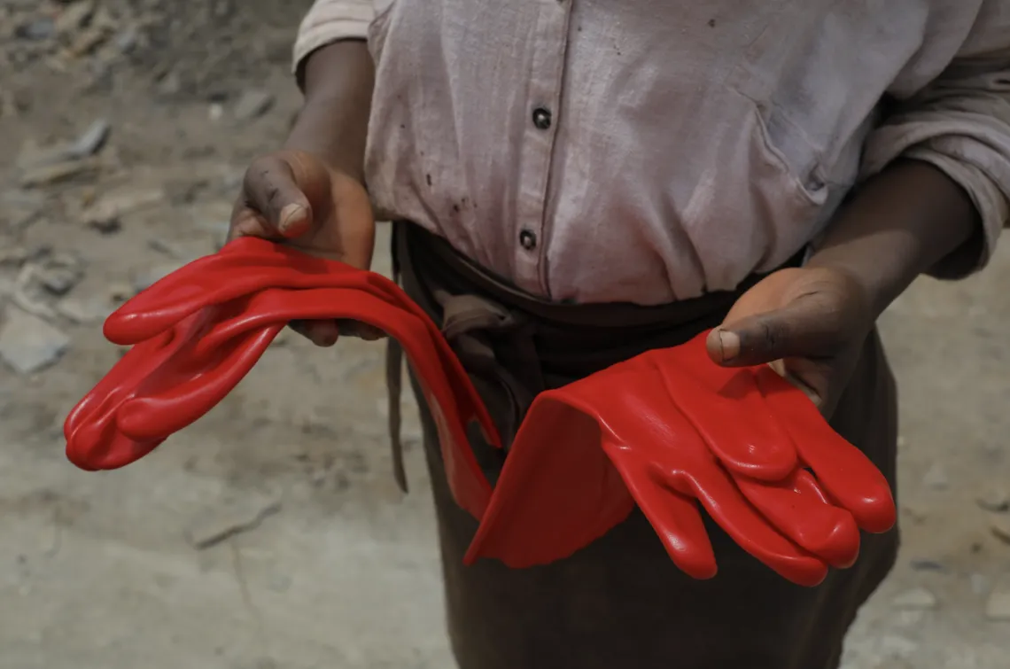 a factory worker showing of gloves
