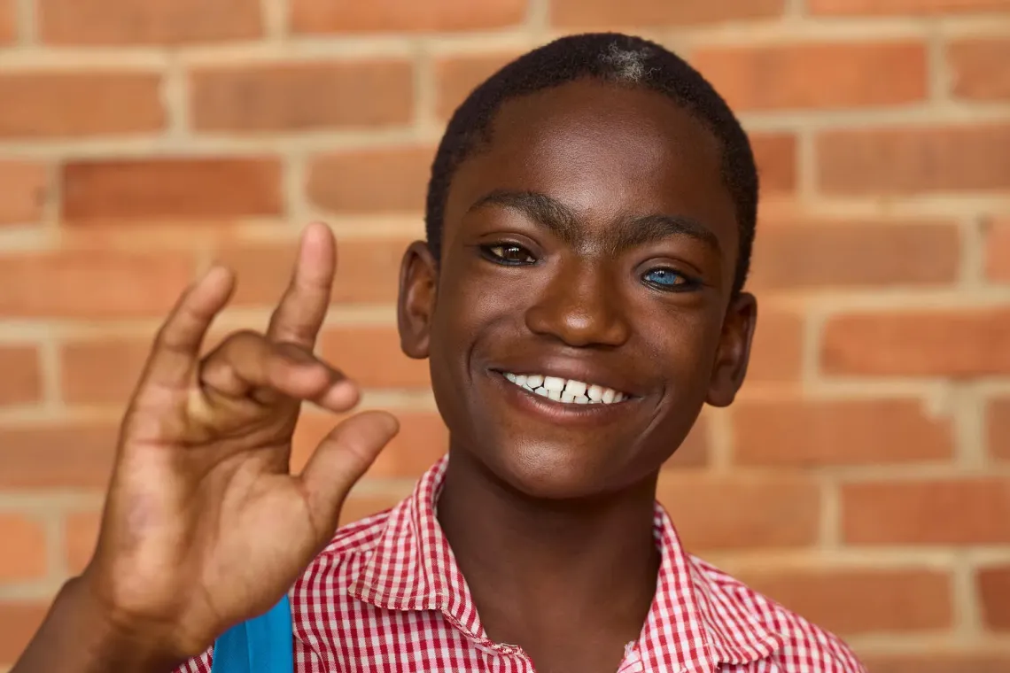 In Tamale, Ghana, Anass from the Tamale School for the Deaf smiles and signs &ldquo;I love you&rdquo; during a portrait at Red Clay Studio-a moment that celebrates UNICEF&rsquo;s commitment to inclusive education and creative expression, showing how every child shares their voice beyond words.