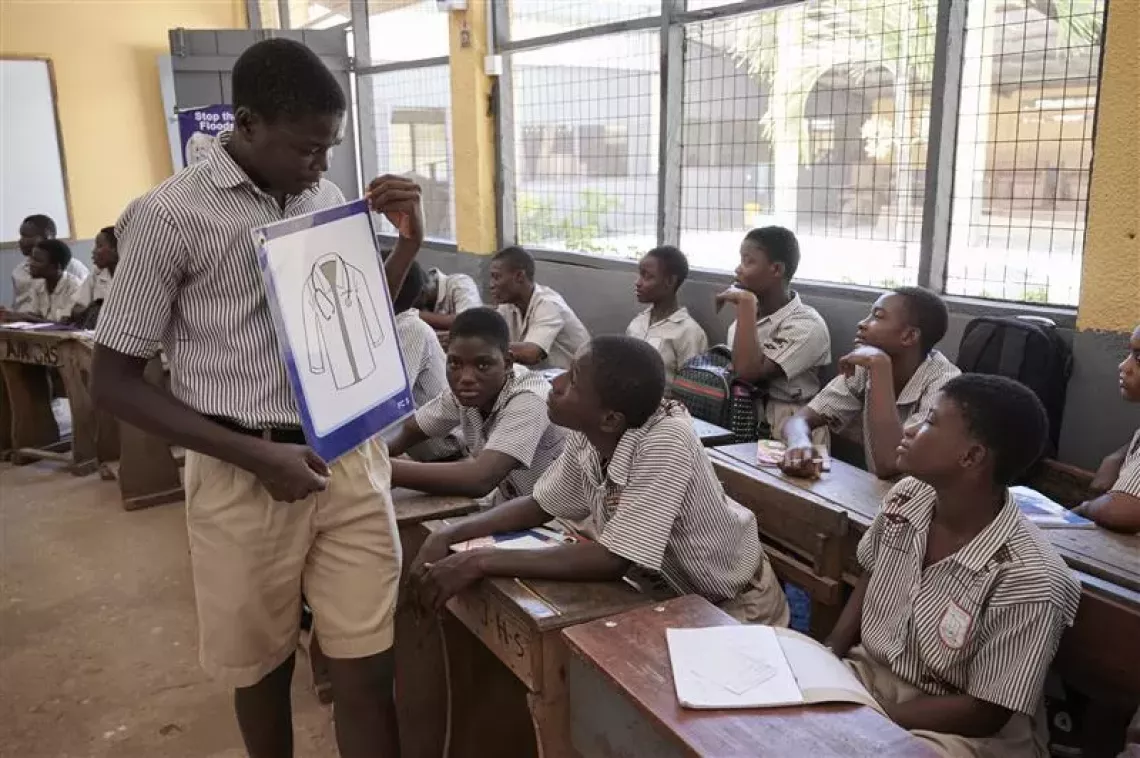 Daniel, 17, shows a flashcard to his colleagues. 